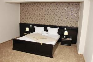 a bedroom with a large bed with two night stands at Hotel Imperium in Suceava