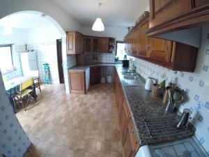 a kitchen with wooden cabinets and a counter top at My Powderwave Ericeira in Ericeira