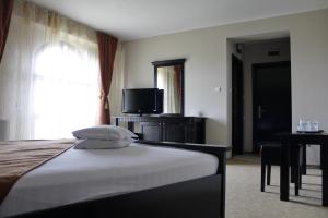 a hotel room with a bed and a television at Hotel Imperium in Suceava