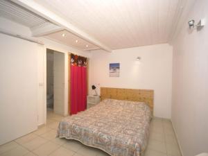 ポッジョ・メッザナにあるCosy Holiday Home in Poggio Mezzana on the Beachsideのベッドルーム1室(ベッド1台、赤いカーテン付)
