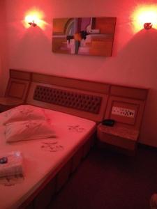 1 dormitorio con 1 cama con luz roja y espejo en Hotel Jardim América ( Adults only), en São Paulo