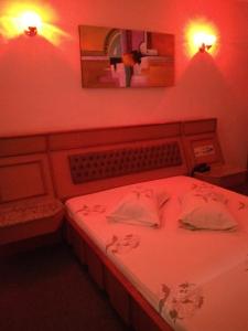 a bedroom with a bed with red lighting and a mirror at Hotel Jardim América ( Adults only) in Sao Paulo