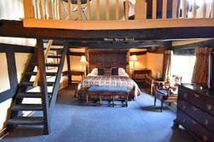 a room with a bed, chair, and stairs at The Old Black Lion in Hay-on-Wye