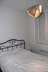 フォール・マオン・プラージュにあるLocation La mouetteのベッドルーム1室(黒いヘッドボードとランプ付きのベッド1台付)