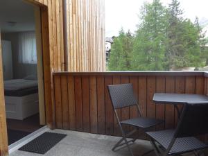 a balcony with two chairs and a table and a window at Apartment Dorfblick in Saas-Fee