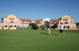 two men playing a game of golf on a golf course at Pestana Sintra Golf Resort & SPA Hotel in Sintra