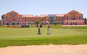 two people playing golf on a golf course at Pestana Sintra Golf Resort & SPA Hotel in Sintra