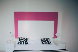 a bedroom with a white bed with a purple headboard at Hotel Elite in Salsomaggiore Terme