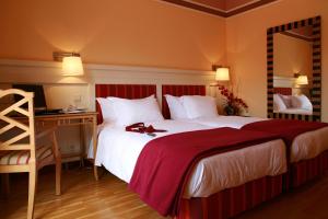 a hotel room with a large bed and a desk at Pestana Sintra Golf Resort & SPA Hotel in Sintra