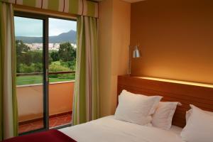 a hotel room with a bed and a window at Pestana Sintra Golf Resort & SPA Hotel in Sintra