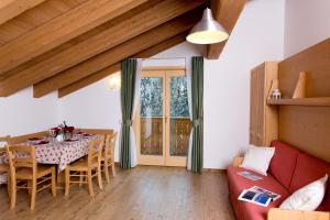 a dining room with a table and a red couch at Residence Civetta in Val di Zoldo