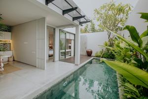 an indoor pool in a house with plants at Casamaya Villa in Legian