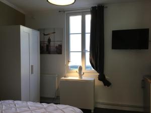 1 dormitorio con cama y ventana en L'Aviateur centre 400m gare wifi linge de pressing, en Niort