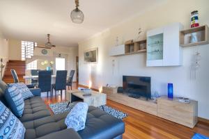 ein Wohnzimmer mit einem Sofa und einem TV in der Unterkunft Villa Araujo Da Costa by HR Madeira in Garajau