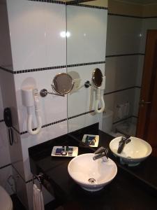 a bathroom with two sinks and a mirror and a phone at Pestana Sintra Golf Resort & SPA Hotel in Sintra