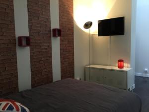 una camera con letto e TV a parete di Le Victoria centre 400m gare wifi linge de pressing a Niort