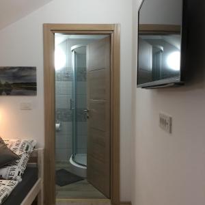 a bathroom with a shower and a glass door at Sobe-Rooms Kvatric in Zagreb