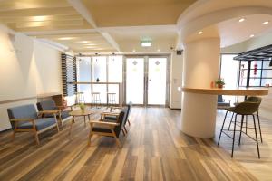 a lobby with chairs and tables and a bar at Flora Inn in Anping