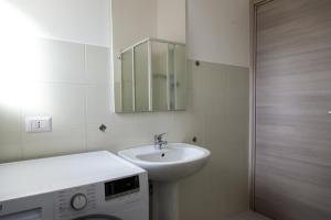 a bathroom with a sink and a washing machine at San Teodoro in San Teodoro