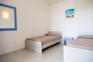 a bedroom with two beds and a mirror at San Teodoro in San Teodoro