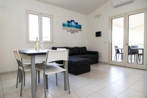 a living room with a table and a couch at San Teodoro in San Teodoro