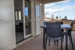 a patio with a table and chairs on a balcony at San Teodoro in San Teodoro