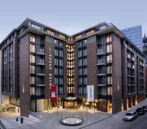 a large building with a parking lot in front of it at Lindner Hotel Hamburg am Michel, part of JdV by Hyatt in Hamburg