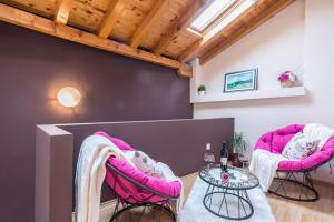 a living room with pink chairs and a table at Old Town House Pakoštane in Pakoštane