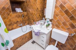 a bathroom with a sink and a toilet and a tub at Old Town House Pakoštane in Pakoštane