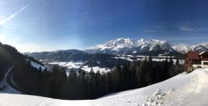una montaña cubierta de nieve con montañas a lo lejos en Bucheggerhof en Schladming