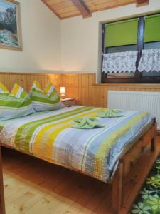a bedroom with a bed with green and yellow pillows at Apartmán Lukáš in Ždiar