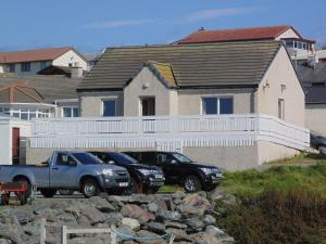 two trucks parked in front of a house at Da Milk Shop Holiday Home in Scalloway