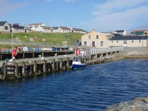 a boat is docked next to a pier at Da Milk Shop Holiday Home in Scalloway