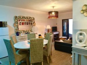 a dining room and living room with a table and chairs at ColinaSol Vale Centeanes Appartement vue mer in Carvoeiro