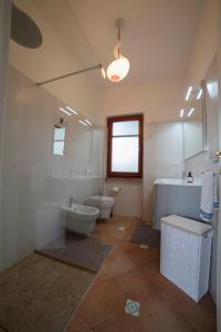 ポルト・サント・ステーファノにあるBeach Front Villa-Families & Pet Friendlyのバスルーム(洗面台、トイレ、バスタブ付)