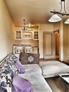 a living room with a couch and a kitchen at Apartment City Life in Podgorica