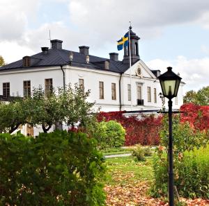 una casa blanca con una bandera encima en Gimo Herrgård, en Gimo