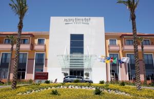 a building with palm trees in front of it at Pestana Sintra Golf Resort & SPA Hotel in Sintra