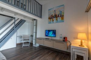 a living room with a television and a staircase at Superbe studio en duplex, vue sur mer et piscine in Le Gosier