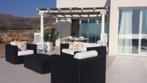 um pátio com 2 cadeiras e uma pérgola em My Heaven em Favignana