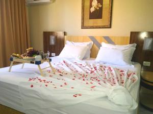 a white bed with red hearts on it at King Konfort Hotel in Maringá
