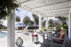 a patio with a table and chairs next to a pool at Casa Margot in Cadaqués