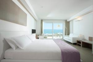 a bedroom with a bed with a view of the ocean at Hotel Aurora in Lido di Jesolo