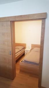 1 dormitorio con 2 camas y puerta corredera de cristal en Appartement De Martin, en Aurach bei Kitzbuhel
