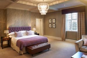 a bedroom with a purple bed and a chandelier at The Manor Elstree in Elstree
