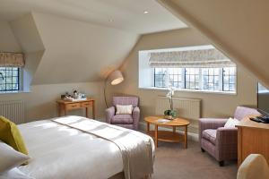 a bedroom with a bed and two chairs and a table at The Manor Elstree in Elstree