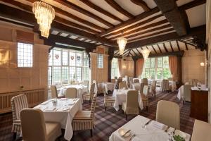 a restaurant with white tables and chairs and windows at The Manor Elstree in Elstree +31 photos