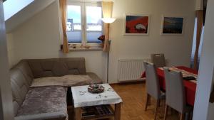 ein Wohnzimmer mit einem Sofa und einem Tisch in der Unterkunft Apartma Ravbar in Kranjska Gora