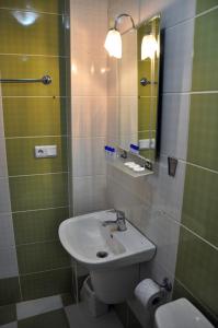 y baño con lavabo y espejo. en Hekimoğlu Hotel, en Erzurum