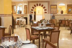un restaurante con mesas y sillas y una persona de fondo en Eurostars Maimonides, en Córdoba